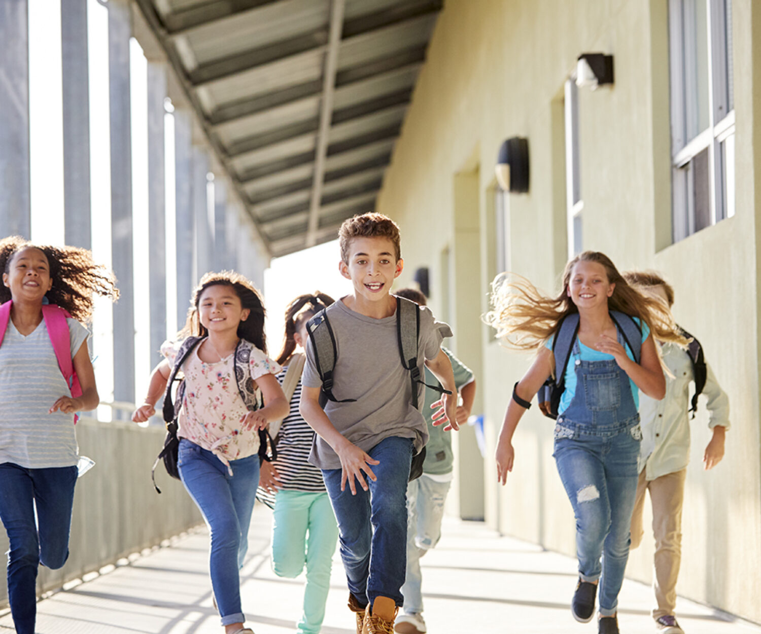 Kids running in elementary school corridor, close up
